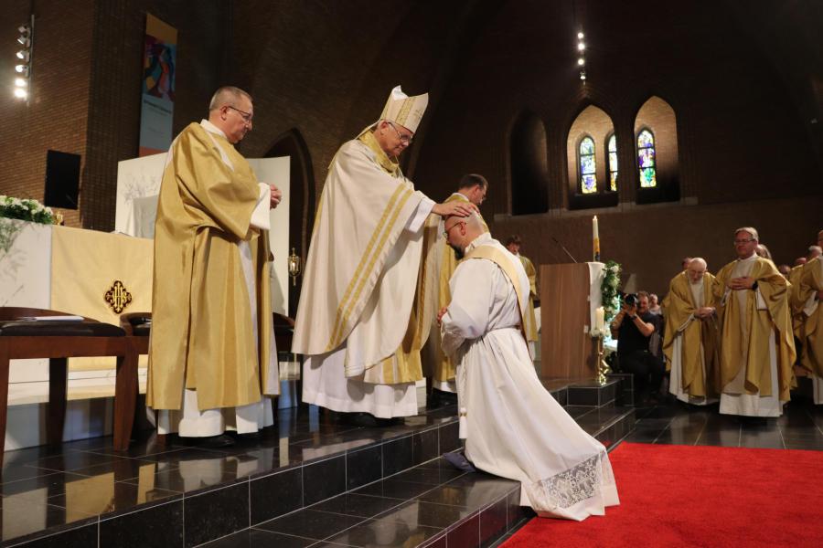 De bisschop en alle aanwezige priesters leggen de wijdeling in stilte de handen op. Het is het eeuwenoude gebaar waarmee we bidden om de gaven van de Geest © Jente Vandewijer