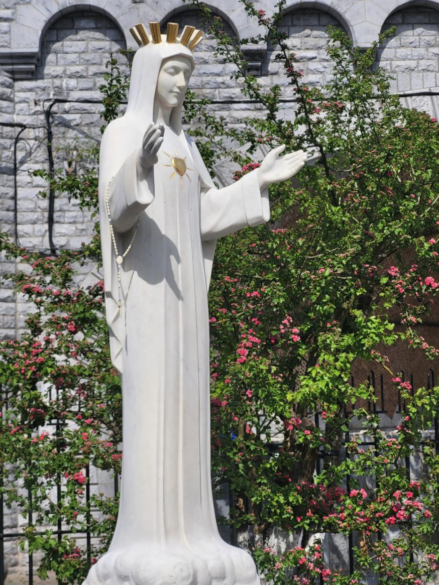 Het gerestaureerde Mariabeeld in de tuin 